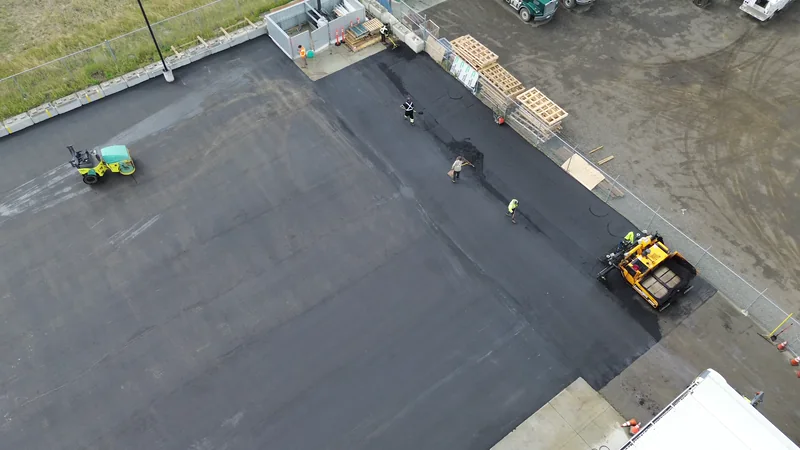 High aerial of the finished compound lot with a roller making its final passes