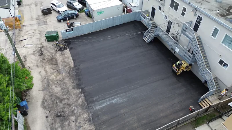 Aerial of a freshly repaved rear parking lot behind a Calgary commercial building